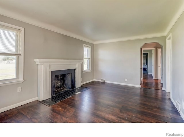 unfurnished living room featuring arched walkways, dark wood-style flooring, a fireplace, visible vents, and baseboards