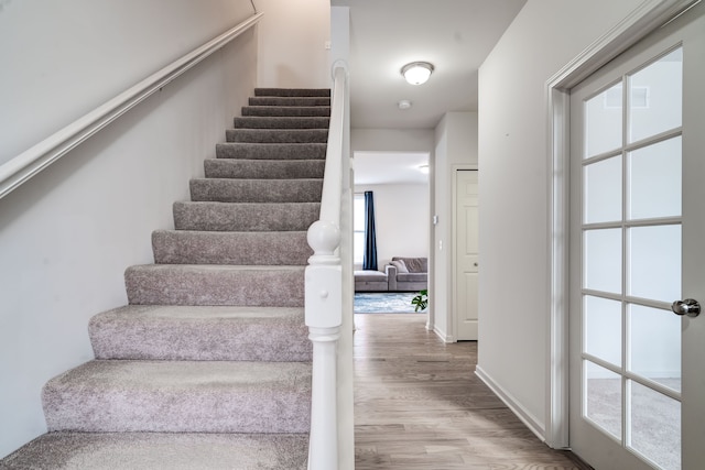 stairway with wood finished floors and baseboards