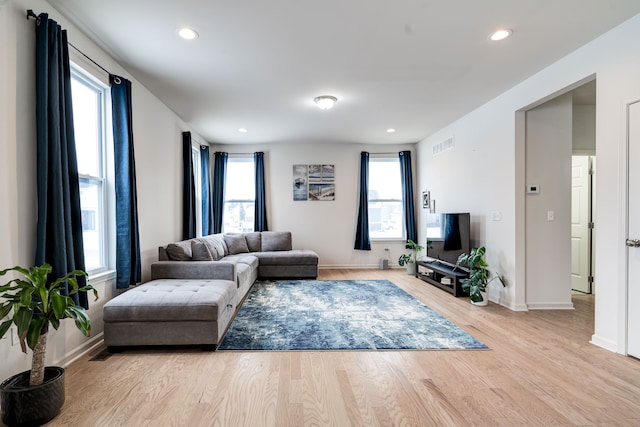 living room featuring recessed lighting, a healthy amount of sunlight, visible vents, and wood finished floors