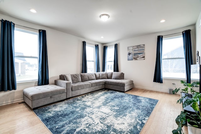 living room featuring baseboards, wood finished floors, and recessed lighting