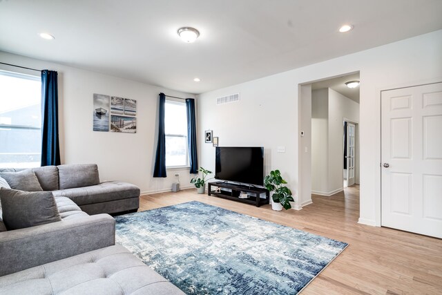 living area featuring light wood-type flooring, visible vents, and recessed lighting