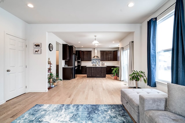 living area featuring light wood-style floors, recessed lighting, and baseboards