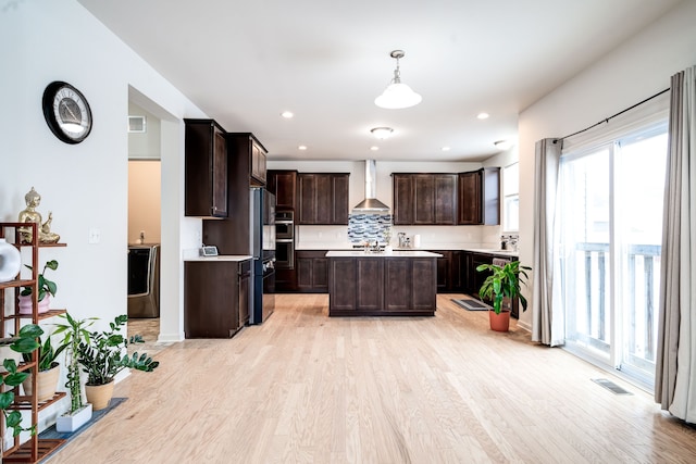 kitchen featuring light countertops, visible vents, light wood-style flooring, dark brown cabinetry, and wall chimney exhaust hood