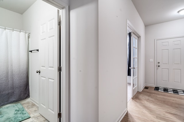 foyer featuring baseboards and light wood finished floors