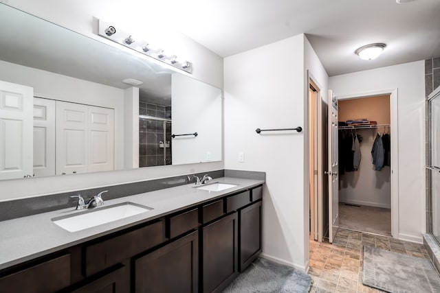 bathroom with double vanity, a stall shower, a sink, and stone finish floor