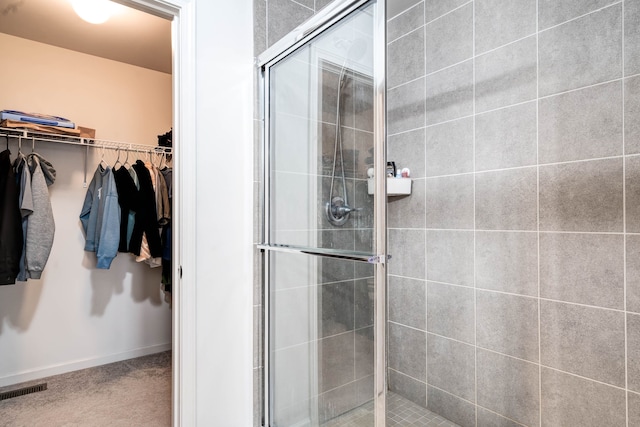 full bathroom featuring a walk in closet, visible vents, and a shower stall