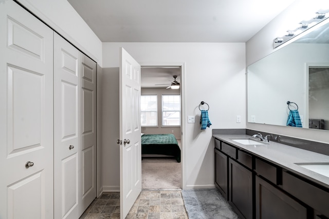 full bathroom featuring ensuite bathroom, double vanity, stone finish floor, and a sink