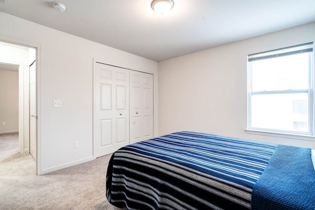 bedroom with a closet, baseboards, and carpet flooring