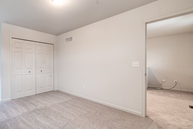 unfurnished bedroom with a closet, baseboards, visible vents, and carpet flooring