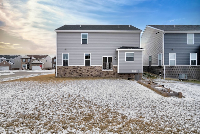 snow covered house with central AC unit