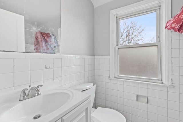 bathroom featuring tile walls, toilet, and vanity