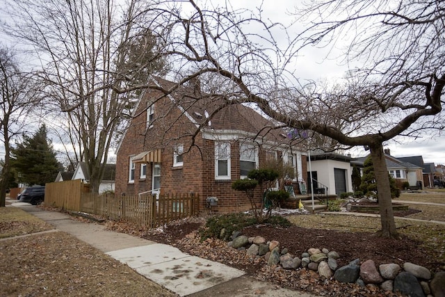 view of front facade featuring a garage, a fenced front yard, and brick siding