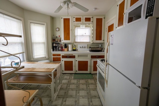 kitchen featuring white appliances, tasteful backsplash, a ceiling fan, light countertops, and light floors