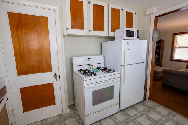 kitchen with light floors, white appliances, and white cabinetry