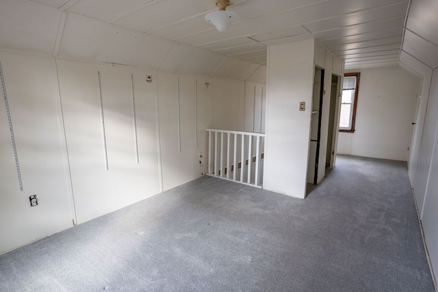 unfurnished room featuring vaulted ceiling and carpet flooring