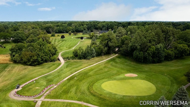 birds eye view of property with view of golf course and a view of trees