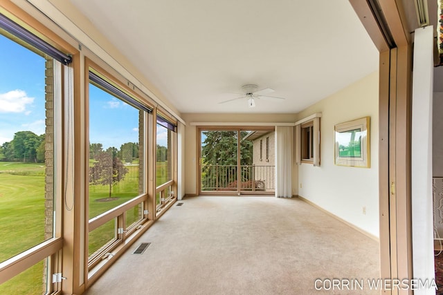 unfurnished sunroom featuring ceiling fan and visible vents