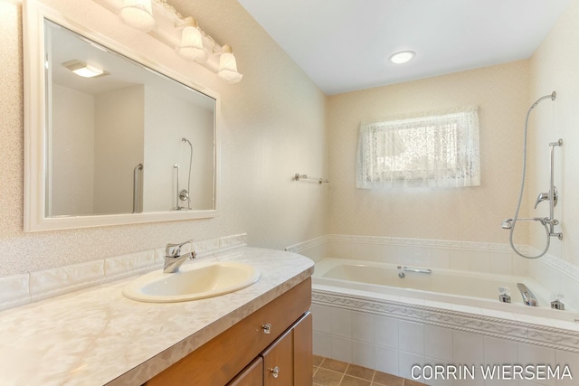 bathroom featuring tiled bath and vanity