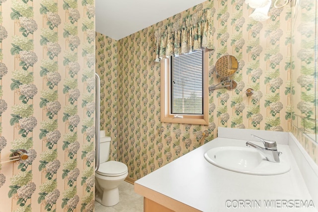 bathroom with tile patterned floors, vanity, toilet, and wallpapered walls