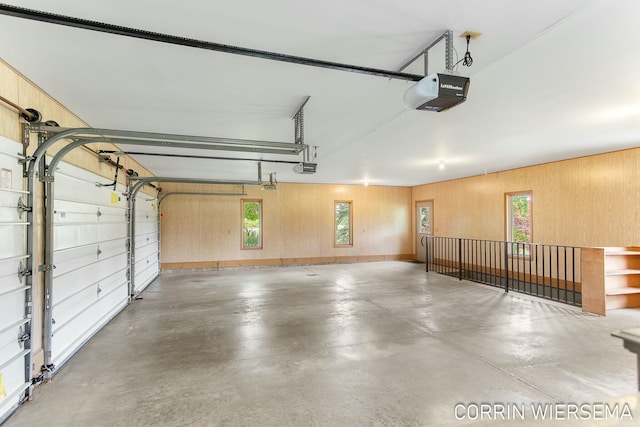 garage featuring a garage door opener and wood walls