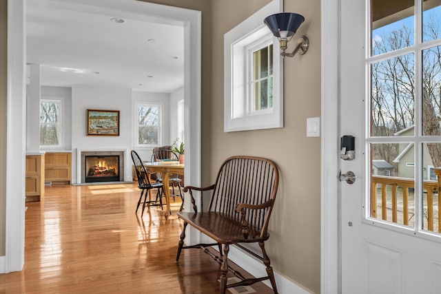 interior space featuring light wood finished floors and a warm lit fireplace