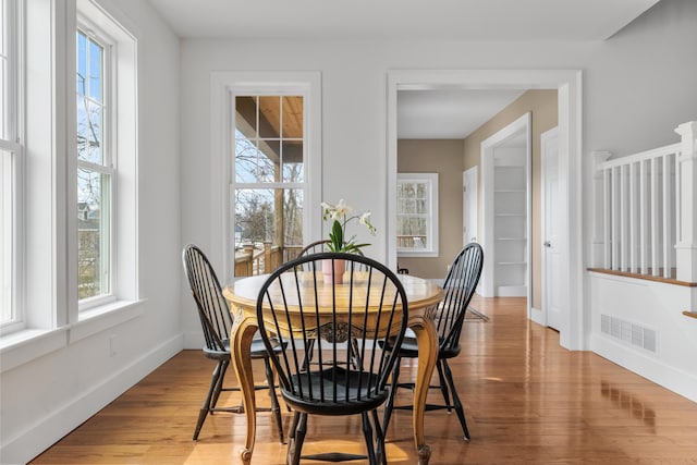 dining space featuring visible vents, baseboards, and wood finished floors