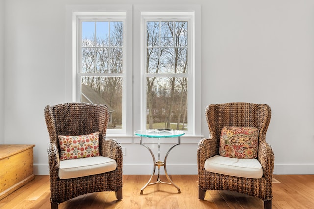 sitting room featuring baseboards, a wealth of natural light, and wood finished floors