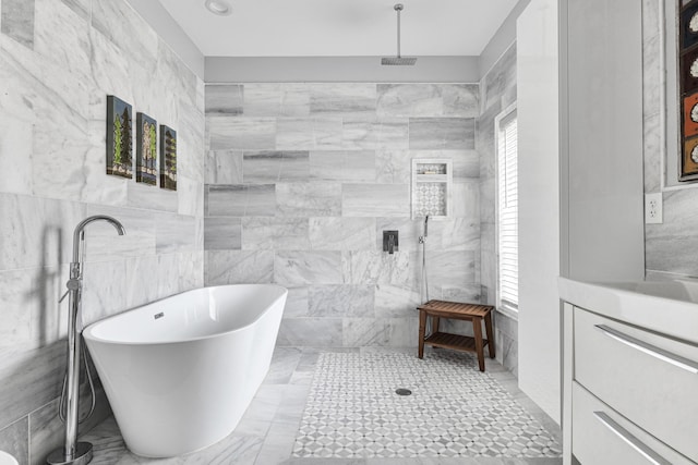 full bathroom with a freestanding tub, tiled shower, and tile walls