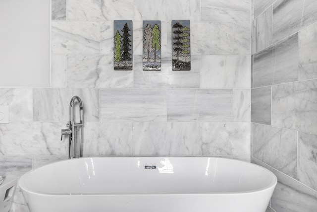 bathroom with a soaking tub and tile walls