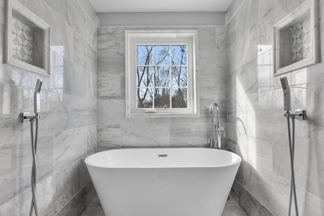 bathroom featuring tile walls and a freestanding bath