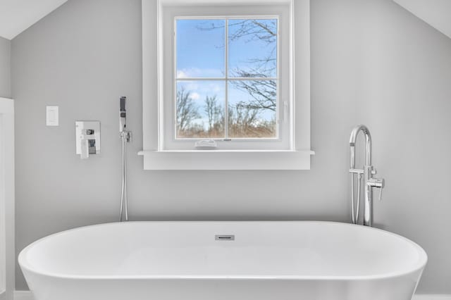 bathroom featuring a soaking tub and plenty of natural light