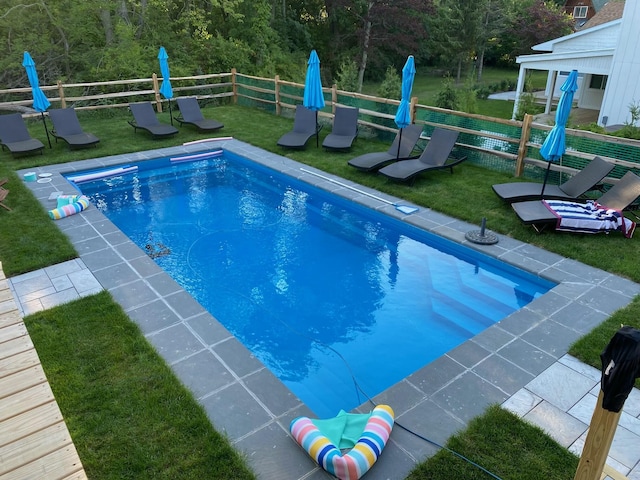 view of pool with fence, a fenced in pool, and a yard