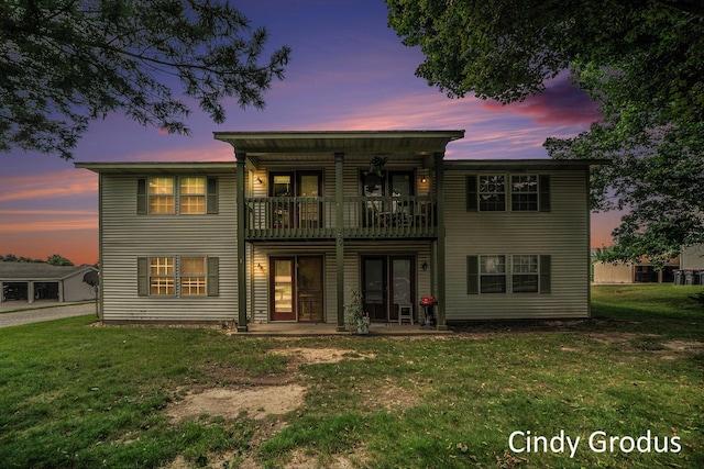 back of property featuring a lawn and a balcony