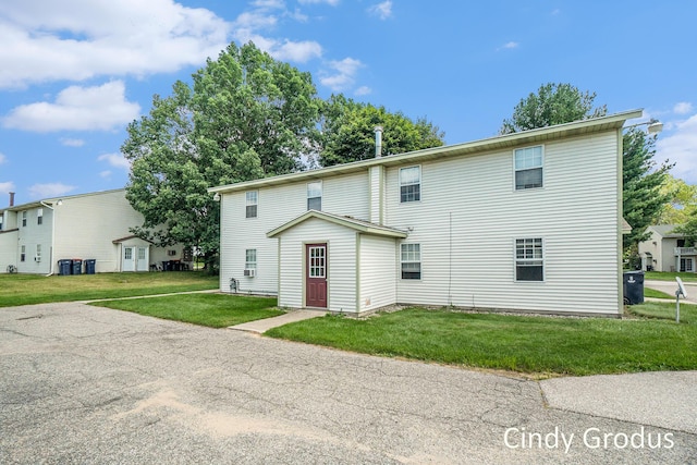 rear view of property featuring a lawn