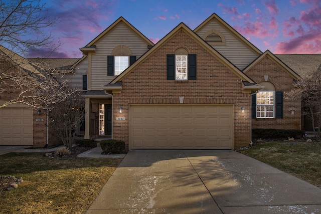 traditional-style house featuring brick siding, concrete driveway, and a front lawn