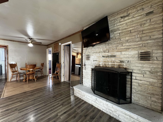11698 Elm Park Dr, Manitou Beach, MI 49253 - living room featuring a ceiling fan, a stone fireplace, wood finished floors, and crown molding