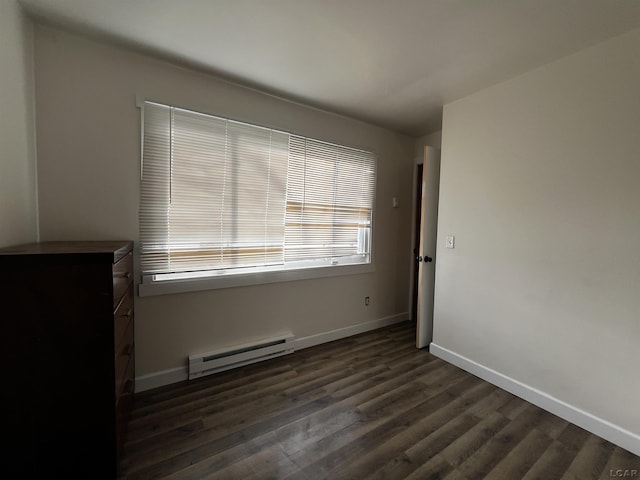 11698 Elm Park Dr, Manitou Beach, MI 49253 - spare room with a baseboard heating unit, dark wood-type flooring, and baseboards