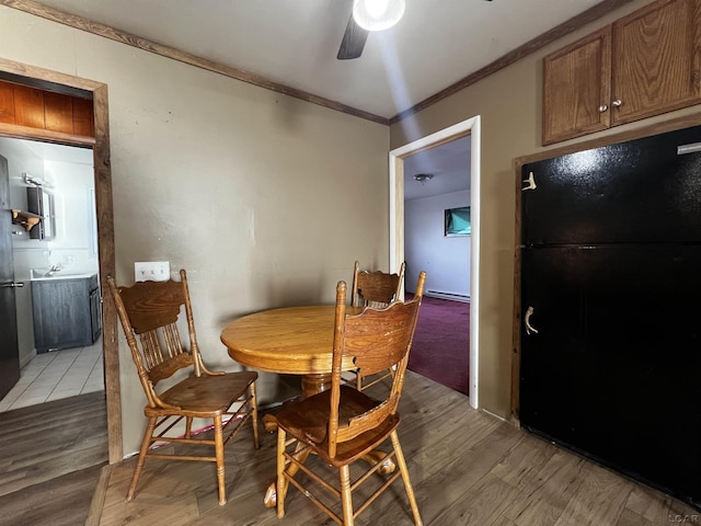 dining area with light wood finished floors, ceiling fan, and ornamental molding