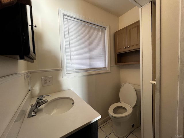 bathroom with toilet, tile patterned floors, and vanity