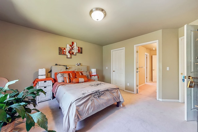 bedroom featuring light colored carpet and baseboards