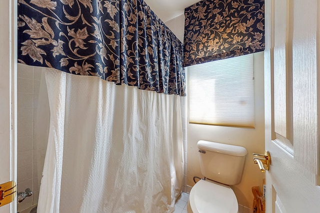 full bathroom featuring a shower with shower curtain, toilet, and tile patterned floors