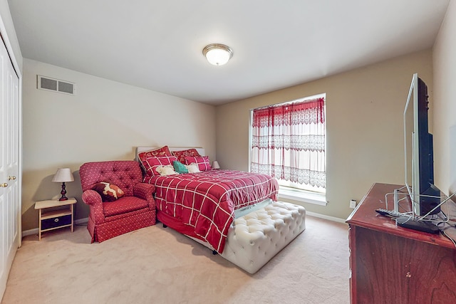 carpeted bedroom featuring a closet, visible vents, and baseboards