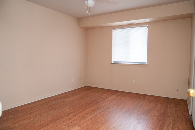 spare room featuring a ceiling fan, visible vents, light wood-style flooring, and baseboards