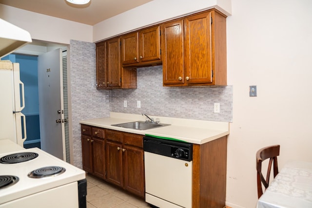 kitchen with light tile patterned floors, light countertops, backsplash, a sink, and white appliances