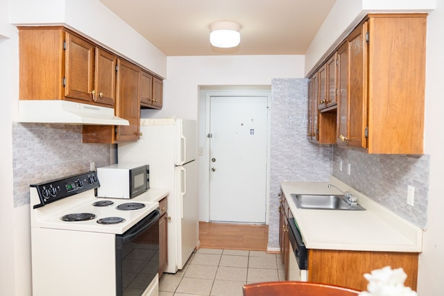 kitchen featuring black microwave, under cabinet range hood, range with electric cooktop, a sink, and light countertops