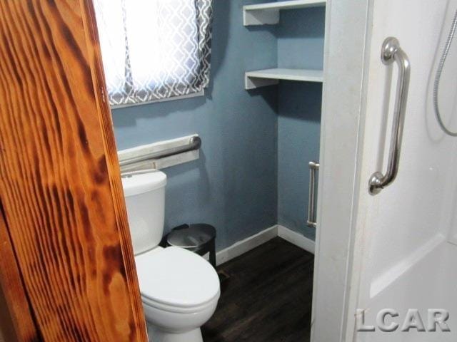 bathroom featuring toilet, baseboards, and wood finished floors