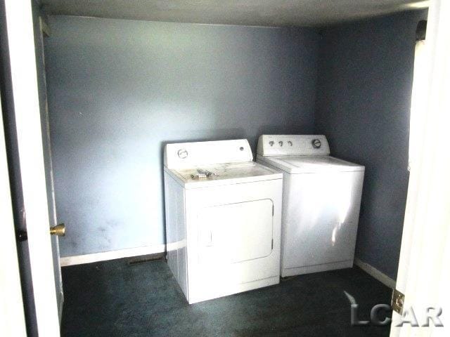 washroom featuring washer and dryer, laundry area, and baseboards