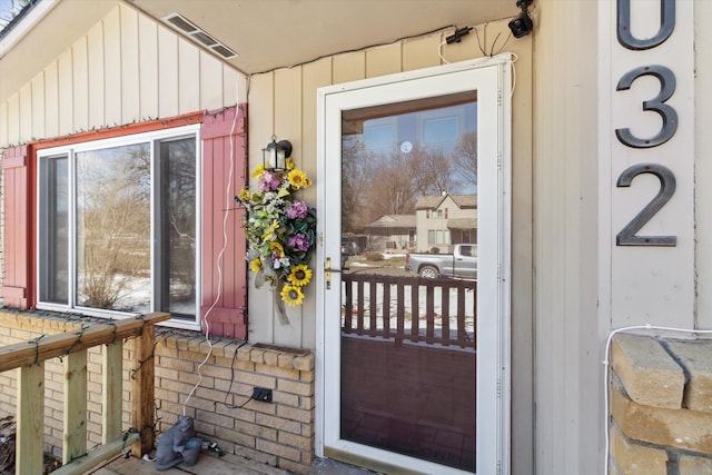 entrance to property featuring board and batten siding and visible vents