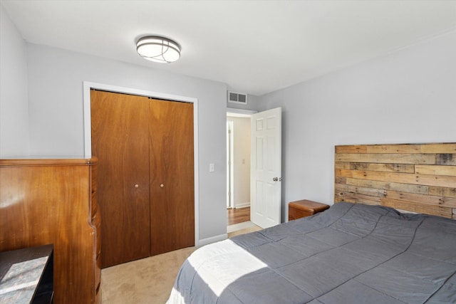 carpeted bedroom featuring a closet and visible vents