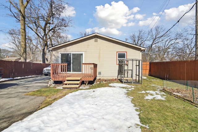 rear view of house featuring a yard, fence, and a wooden deck